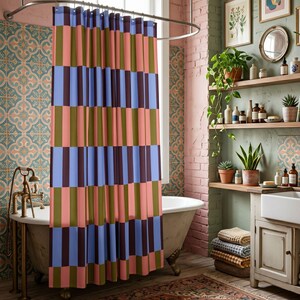 Pu&ograve; includere: Una tenda da doccia caratterizzata da un motivo a blocchi verticali ripetuti in colori alternati azzurro, verde oliva e rosa tenue. Il tessuto pende da un'asta metallica curva, mostrando una serie di segmenti rettangolari uniformi disposti in file.
