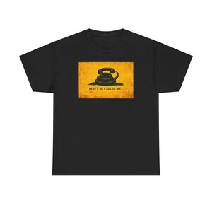 May include: Black t-shirt with a distressed yellow rectangle design. It features a coiled telephone graphic and the text "DON'T BE CALLIN ME". The shirt is made of a soft, comfortable material.