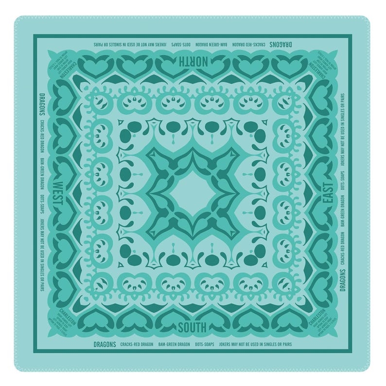 May include: Square bandana in shades of teal and turquoise with a symmetrical design. The design includes heart shapes, swirls, and text indicating directions and phrases like "Dragons" and "Jokers may not be used in singles or pairs."