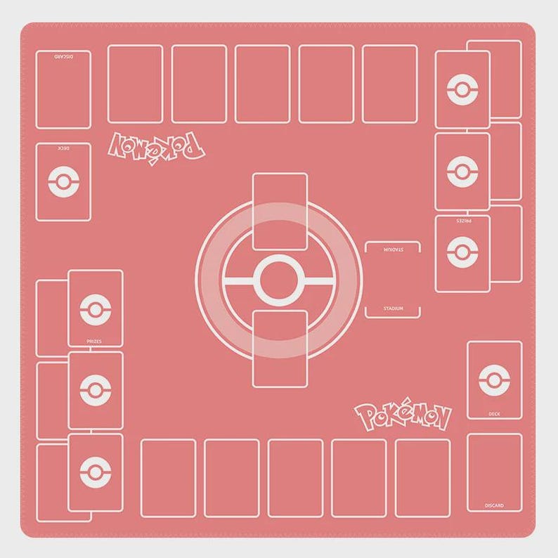 May include: A coral-colored playmat for a card game, featuring a white design with card placement zones, a central circular graphic, and the word "Pok&eacute;mon" in white lettering. The mat is designed for organized gameplay.