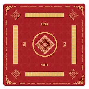 May include: A square red Mahjong mat featuring a central gold diamond emblem, four player positions labeled North, South, East, and West, and printed instructions for Charleston and Dragon rules in gold text along the edges and corners.