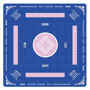 May include: A square blue Mahjong mat featuring a central white circle with a diamond pattern and dice. The mat includes labeled North, South, East, and West positions, along with Charleston instructions and rectangular tile racks in light pink.