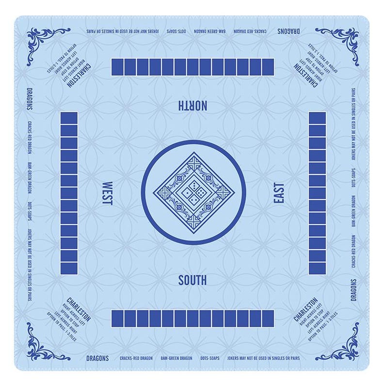 May include: A light blue Mahjong mat featuring a central diamond design with dice pips, four player positions labeled North, South, East, and West, and four tile racks. The mat includes printed Charleston rules and dragon suit terminology.