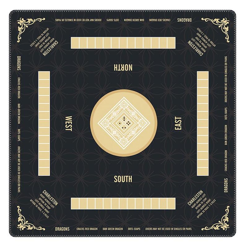 May include: A square Mahjong game mat in black with gold accents. The mat features a central circular design with a diamond pattern, four rectangular tile racks, and directional labels for North, South, East, and West. Text includes Charleston rules and Dragon suit names.