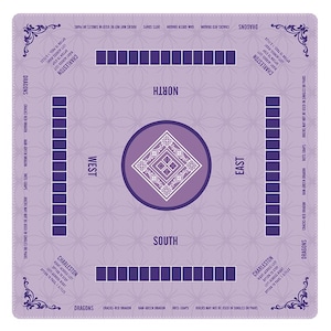 May include: A square lavender Mahjong mat featuring a central diamond pattern, four player positions labeled North, South, East, and West, and rows of dark purple squares. The mat includes printed text detailing Charleston rules and dragon tiles.