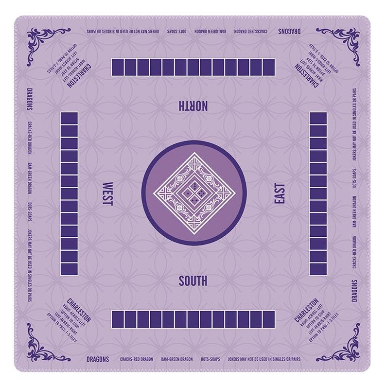 May include: A square lavender Mahjong mat featuring a central diamond pattern, four player positions labeled North, South, East, and West, and rows of dark purple squares. The mat includes printed text detailing Charleston rules and dragon tiles.