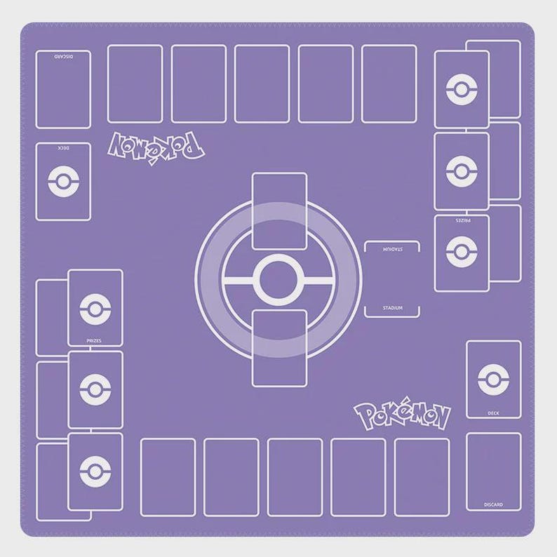 May include: A purple playmat for a card game, featuring a layout with designated areas for cards and game elements. The mat has white outlines and text, including the word "Pok&eacute;mon" and icons. The overall design is symmetrical and organized.
