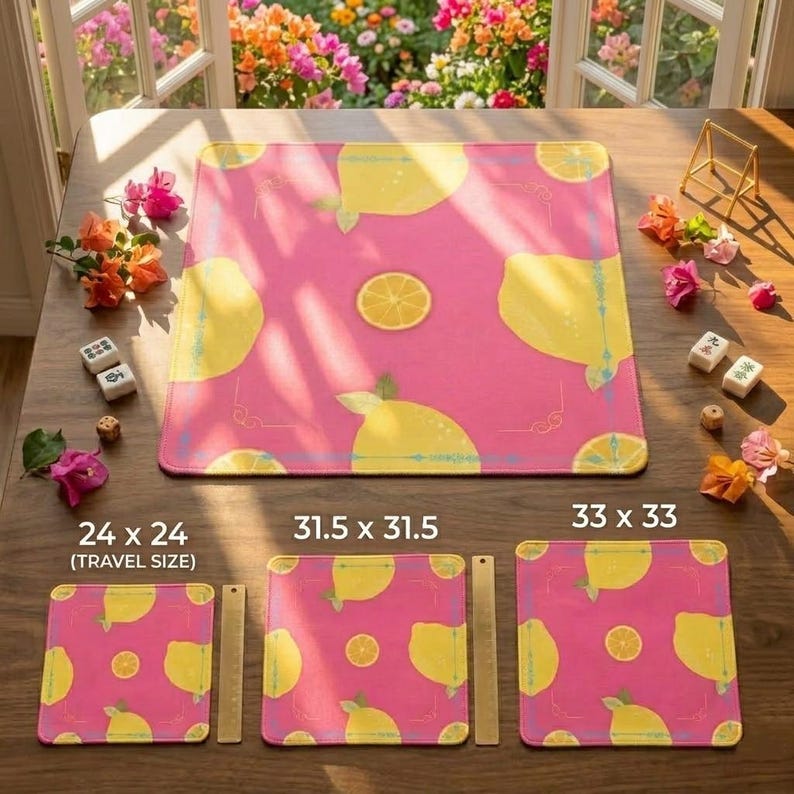 May include: Pink placemats with a lemon pattern. The placemats are available in three sizes: 24 x 24 inches (travel size), 31.5 x 31.5 inches, and 33 x 33 inches. The design features yellow lemons and lemon slices.