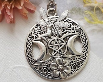 May include: Silver necklace with a circular pendant featuring a triple moon, pentacle, and a fairy with wings. The pendant is detailed with intricate knotwork and floral designs.