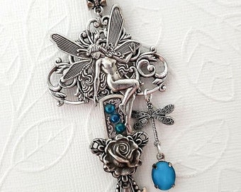 Puede incluir: Collar de llave de plata con una figura de hada, un amuleto de libélula y una piedra preciosa azul. La llave tiene un diseño de rosa y detalles intrincados.