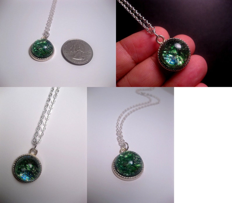 May include: A silver chain necklace with a green and blue iridescent glass pendant. The pendant is round and has a silver rim.