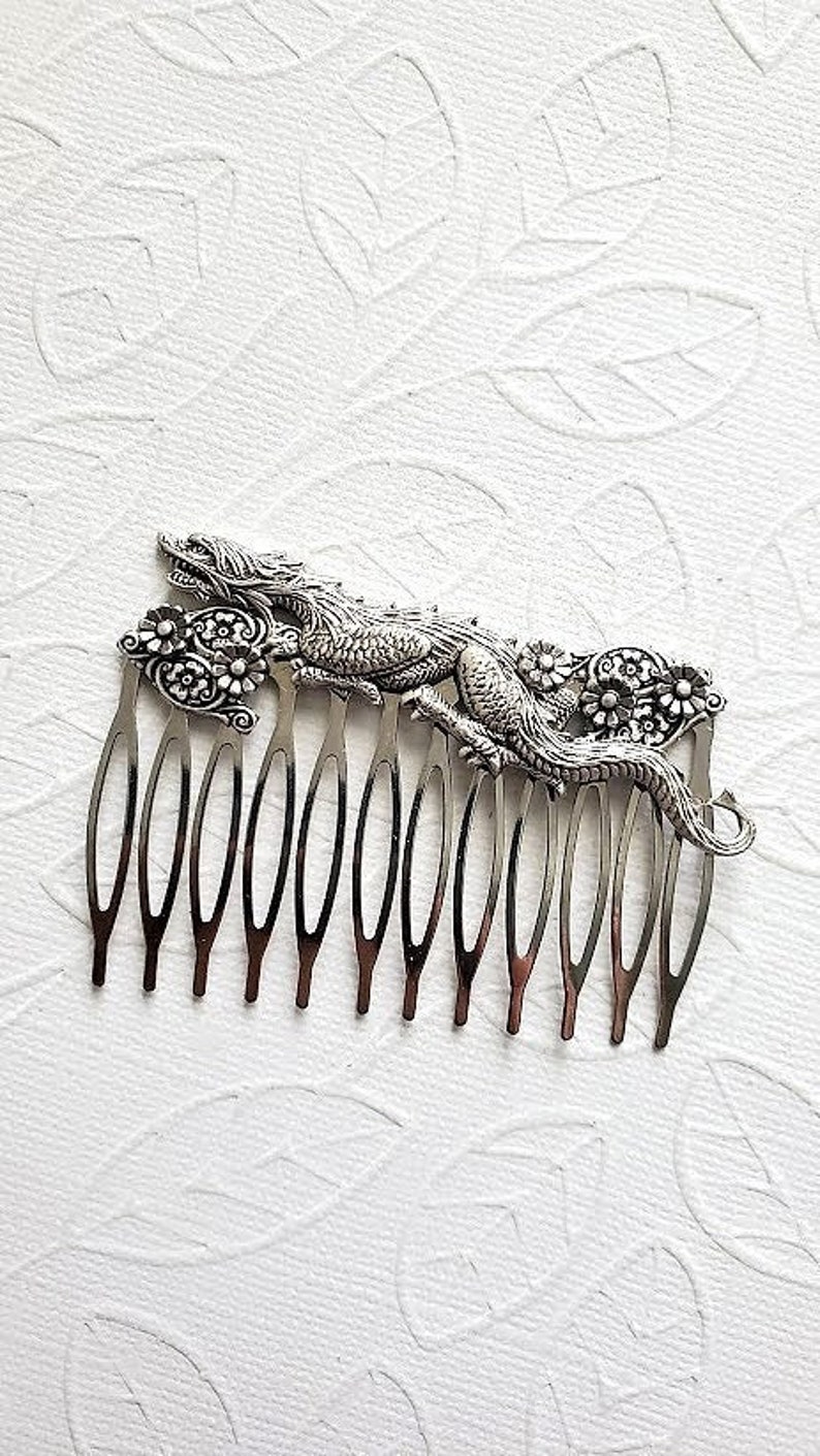 May include: Silver hair comb with a detailed dragon design and floral accents.