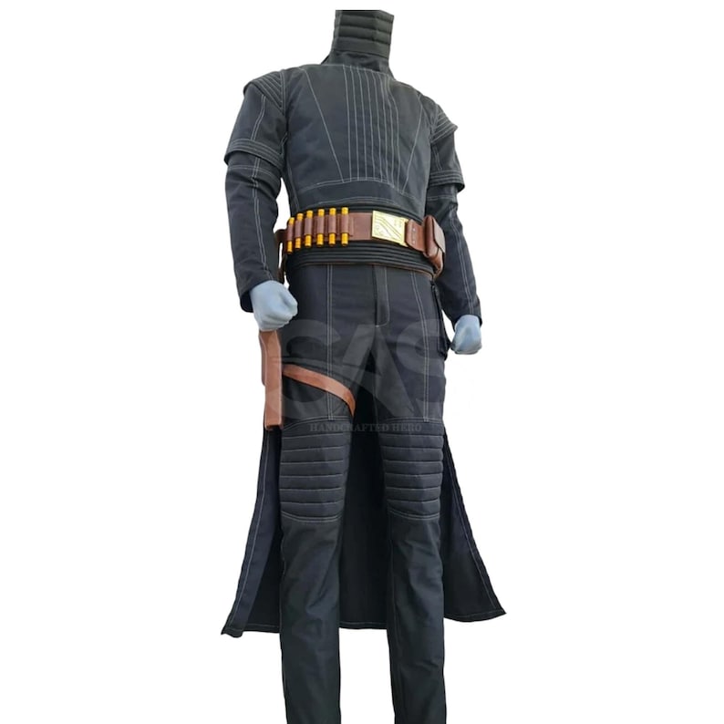 May include: A black long-sleeved jacket and matching trousers set featuring quilted padding on the shoulders, neck, and knees. A brown leather utility belt with yellow cylindrical accents and a holster is worn around the waist over the dark outfit.
