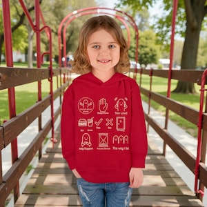May include: A red hoodie featuring white graphic icons and text. The text includes phrases like "Too Loud", "Yes", and "Privacy". A young person is wearing the sweatshirt while standing on a wooden bridge.