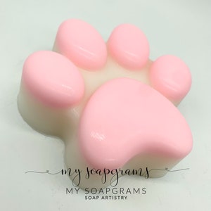 Op de afbeelding: Een roze zeep in de vorm van een hondenpoot met een wit midden. De zeep is gemaakt door My Soapgrams Soap Artistry.