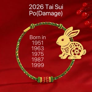 May include: A gold rabbit charm with a floral design is attached to a green and red braided bracelet. The text "2026 Tai Sui Po(Damage)" and birth years 1951, 1963, 1975, 1987, and 1999 are visible. The background is red.