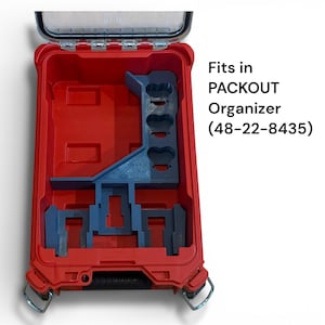 May include: A red plastic storage case with an open lid and a blue custom insert featuring three circular cutouts and two rectangular slots. The text on the right reads: Fits in PACKOUT Organizer (48-22-8435).