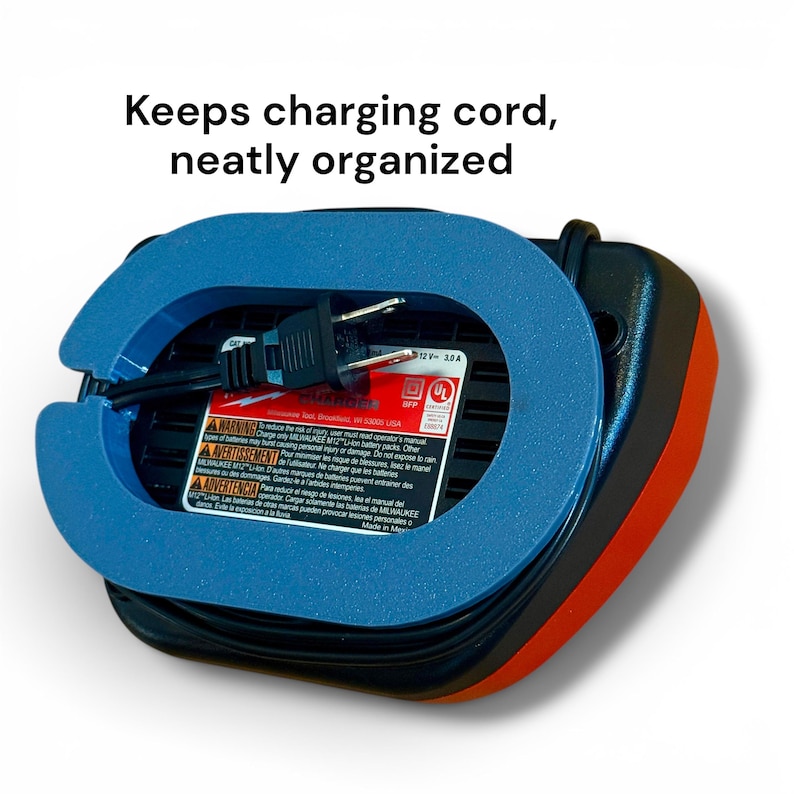 May include: A black and orange battery charger featuring a blue plastic cord organizer attachment. The device includes a black power cord and a label with the text: Keeps charging cord, neatly organized, along with safety warnings.