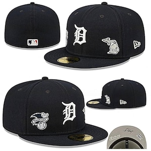 May include: Navy blue baseball cap featuring the Detroit Tigers logo in white. The cap has a flat brim and various embroidered patches, including a Michigan outline and a baseball. The MLB logo is on the back.