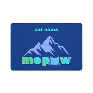May include: A blue rectangular graphic with the text "cat name" above a mountain illustration. Below the mountain is the word "meow" with a cat face replacing the "o" and the word "paw".