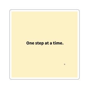 May include: Square sticker with a light yellow background and the text "One step at a time." in black. A small gray star is in the lower right corner. The sticker has a white border.