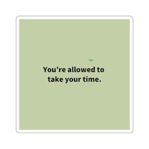 以下が含まれることがあります： 明るい緑色の背景に「You're allowed to take your time」という黒い文字が書かれた正方形のステッカー。右上には小さな緑色の葉のグラフィックがあります。ステッカーには白い縁があります。