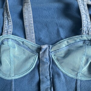 May include: A blue denim halter top with a bustier style bodice and a front zipper closure.