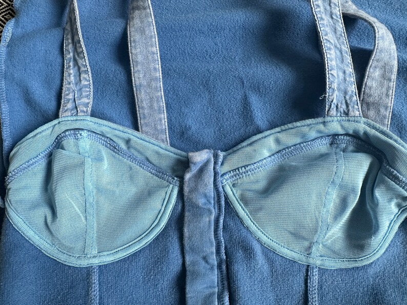May include: A blue denim halter top with a bustier style bodice and a front zipper closure.