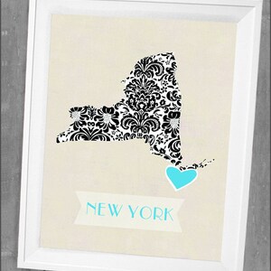 May include: A black and white damask pattern print of the state of New York with a light blue heart in the lower right corner. The text "NEW YORK" is printed in a banner below the state outline.