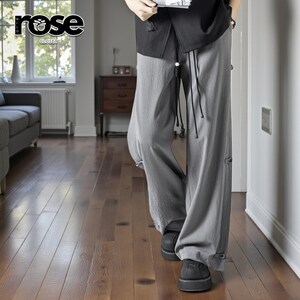 May include: Light gray wide-leg pants with drawstring closure and button details. The pants are part of the "rose closet" collection. The model is wearing black shoes and a black top. The pants have a relaxed fit and are made of a lightweight fabric.