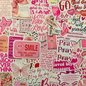 May include: A collage of pink stickers with various designs and text. The stickers feature phrases like "Smile, You're Loved by Jesus," "Pray," and "God will provide." Other designs include butterflies, hearts, and crosses.