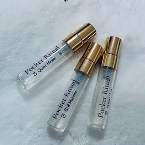May include: A Pocket Ritual Discovery Set featuring three 5ml perfume vials with gold caps. The vials are labeled with the scents "Quiet Hinoki", "Still Matcha", and "Bright Yuzu". The text "5ml x3" is also visible.