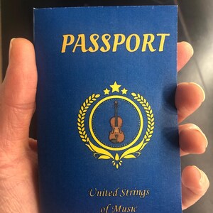 May include: A blue passport with the word "PASSPORT" in gold lettering. The cover features a gold emblem with a violin and the text "United Strings of Music". The passport is held in a hand.