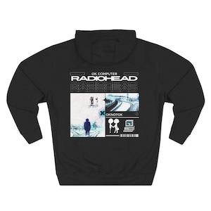 May include: Black hooded sweatshirt featuring the text "OK COMPUTER RADIOHEAD" above a collage of images. The collage includes a person, a highway overpass, and a computer screen with two figures.