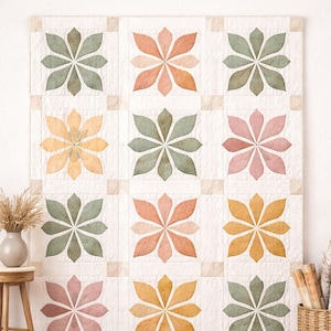 Puede incluir: Un edredón blanco grande con un patrón de cuadrícula que presenta nueve diseños florales en tonos de verde, melocotón, rosa y amarillo. El texto "Urban Bloom Grid - Modern Botanical Quilt Pattern" está en la parte superior. El edredón se exhibe en una pared.