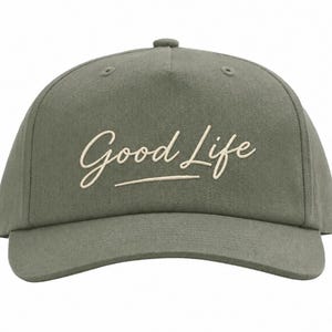 Op de afbeelding: Olijfgroene baseballcap met de geborduurde tekst "Good Life" in een cursief lettertype. De cap heeft een gebogen klep en een gestructureerde kroon. De hoed is gemaakt van een duurzame stof.