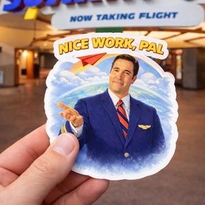 May include: A sticker featuring a smiling man in a blue pilot uniform with a red and white striped tie. The sticker has the text "NICE WORK, PAL" and a paper airplane graphic. The background includes a sky and Earth.