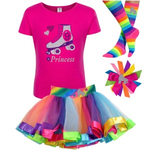 May include: A pink t-shirt with a silver roller skate and the word "Princess" in purple glitter. A rainbow tulle skirt with a silver roller skate and stars. A rainbow striped sock with a silver roller skate. A rainbow hair bow with a silver roller skate.