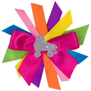 May include: A pink satin bow with a silver glitter roller skate design in the center. The bow is surrounded by eight ribbon tails in a rainbow of colors: pink, orange, yellow, green, blue, purple, and orange.