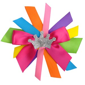 May include: A colorful bow made of satin ribbon with a silver glitter crown in the center. The bow is tied in a knot and the ribbons are arranged in a starburst pattern.