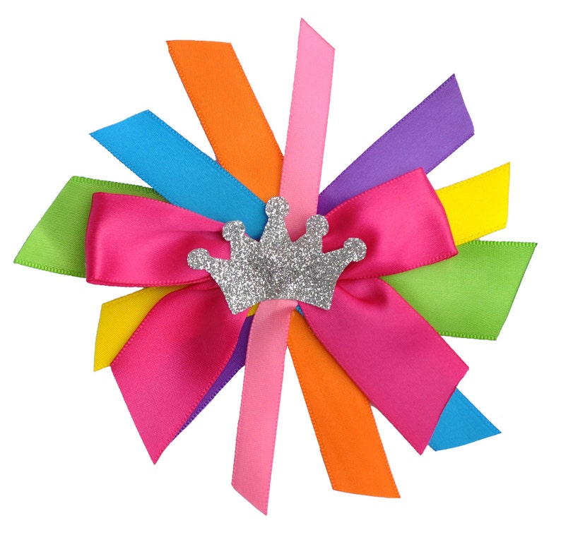 May include: A colorful bow made of satin ribbon with a silver glitter crown in the center. The bow is tied in a knot and the ribbons are arranged in a starburst pattern.