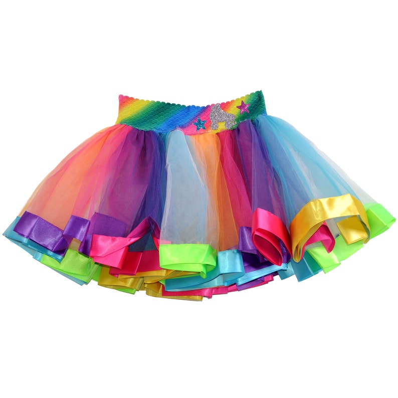 May include: A rainbow tulle skirt with a colorful waistband and a star design. The skirt has multiple layers of tulle and is trimmed with satin ribbon.