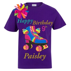 May include: Purple t-shirt featuring a rainbow roller skate graphic, the words "Happy Birthday 9th" and the name "Paisley" in gold glitter.