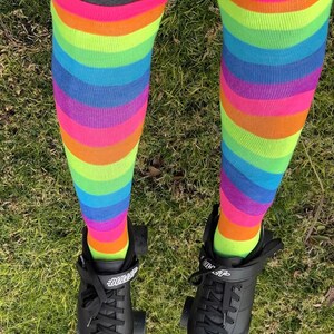 a person wearing rainbow socks and black shoes