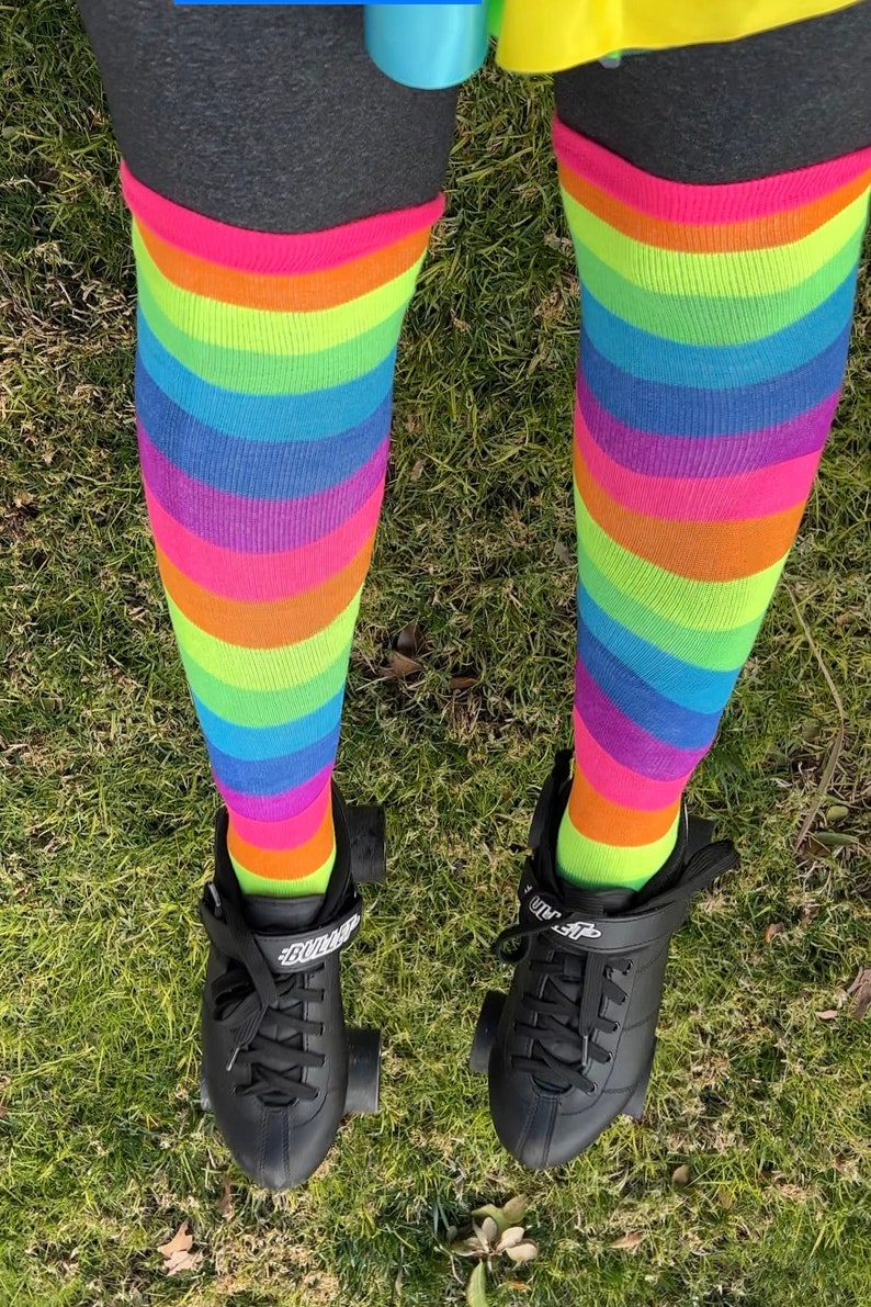 a person wearing rainbow socks and black shoes