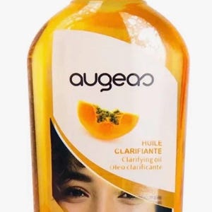 Puede incluir: Una botella amarilla de aceite clarificante con tapa amarilla. La etiqueta presenta la marca "augean", una ilustración de una rodaja de papaya y las palabras "Clarifying Oil". La botella también incluye el texto "PAPAYE" y "Vitamine E".