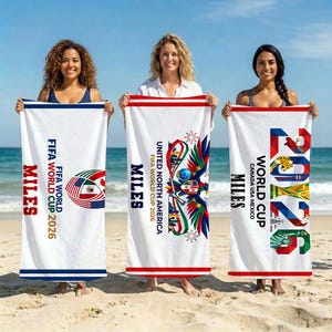 May include: Three white rectangular beach towels featuring FIFA World Cup 2026 branding. The towels display colorful graphics including a soccer ball with flags, an eagle emblem, and the text 2026, along with the word MILES in bold red or black.