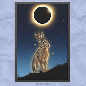 Può includere: Stampa artistica incorniciata raffigurante una lepre marrone seduta su una collina, sotto un cielo notturno stellato e un'eclissi solare. L'opera ha un tema mistico, con il testo "Art NovaVie" in basso.