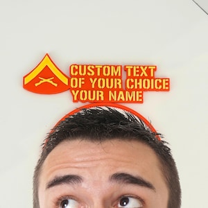 Puede incluir: Insignia de rango militar naranja y amarillo y texto que dice "CUSTOM TEXT OF YOUR CHOICE YOUR NAME". El texto y la insignia están sobre la cabeza de una persona, sobre un fondo blanco.