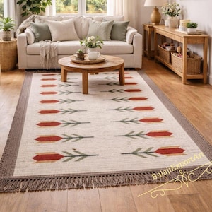 Op de afbeelding: Een witte keramische mok met een zwart handvat en de tekst "But First, Coffee" in een vetgedrukte, zwarte letter. De mok staat tegen een vage achtergrond, wat een gezellige setting suggereert.